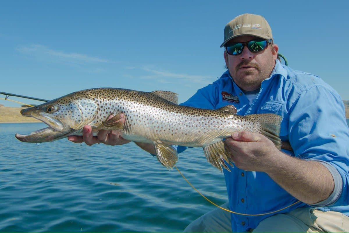 An angler holds a brown trout caught on a Montana river